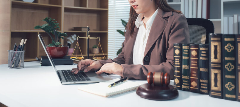 Lawyer Working on Laptop with Legal Symbols in Background 