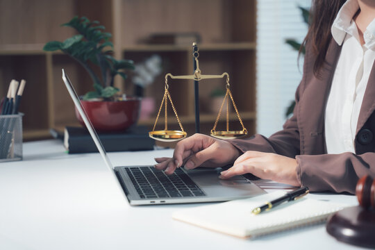 Lawyer Working on Laptop with Legal Symbols in Background 
