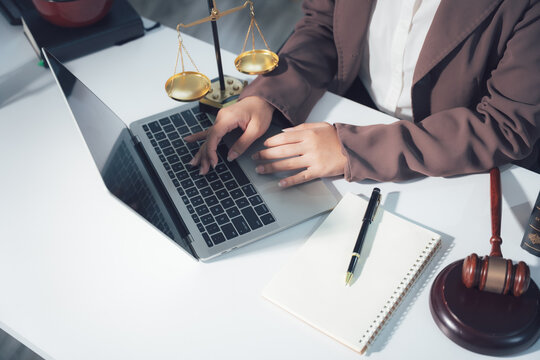 Legal Consultation: A close-up view capturing the atmosphere of legal consultation. A laptop, scales, and documents are arranged on the table, creating a professional environment