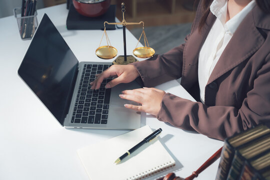Legal Consultation: A close-up view capturing the atmosphere of legal consultation. A laptop, scales, and documents are arranged on the table, creating a professional environment