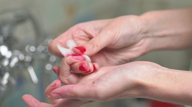 Female removing red nail polish from fingers, showcasing before and after results of nail cleaning, home beauty routine and changing polish color.	
