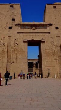 Massive pylon facade of Edfu Temple with giant pharaoh reliefs and central gateway, Egypt. Best preserved ancient Egyptian temple exterior for travel and history projects