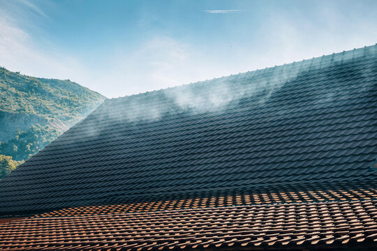 Smoke drifting through traditional tiled rooftops in the mountain village of Njegusi, Montenegro, where the famous Njeguski prsut is traditionally smoked and cured