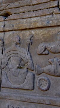 Hieroglyphs and images of Egyptian gods at the Ancient Egyptian Temple of Edfu. Edfu is the site of a Ptolemaic-era Temple of Horus and an ancient settlement in Egypt