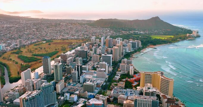 Aerial view of Waikiki skyline and Diamond Head, Honolulu, Hawaii. High rise hotel, beach and volcanic crater under soft sunset light.