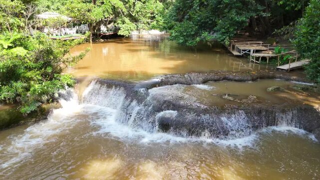 An aerial video showing a muddy waterfall cascading down from the mountains during Thailand's rainy season.