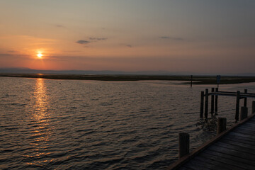 Fototapeta premium Wooden pier at sunset over the Adriatic Sea in Grado Pineta, Friuli Venezia Giulia, Italy