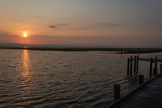 Wooden pier at sunset over the Adriatic Sea in Grado Pineta, Friuli Venezia Giulia, Italy