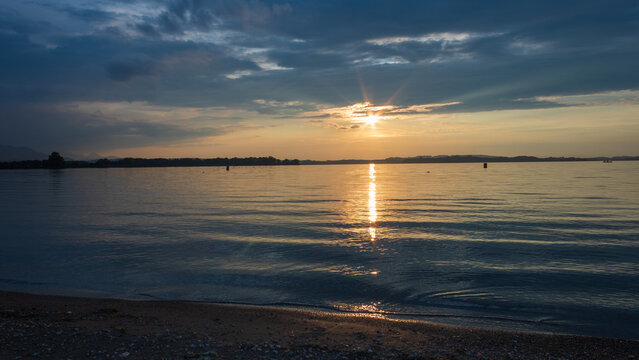 Golden sunset reflected on the calm waters of Lake Chiemsee, Bavaria, Germany