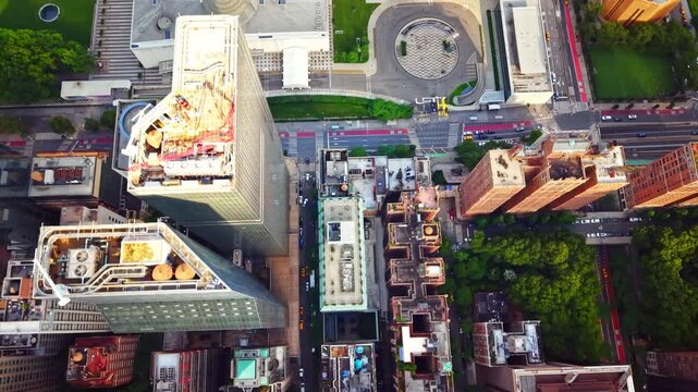 Rooftop terraces and street, New York. Aerial view over green rooftop gardens, brick apartment blocks and a shaded avenue.