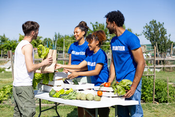 Obraz premium Volunteers distributing fresh produce at community garden market