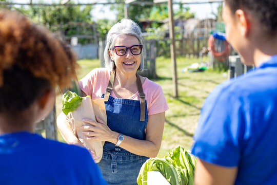 Woman selling fresh vegetables at outdoor community market