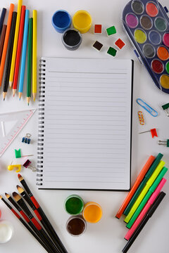 Blank Lined Notebook with Copy Space Surrounded by Colorful Art Supplies and Stationery