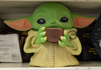 Fototapeta premium Hucha con forma de muñeco de plástico de Grogu, personaje de The Mandalorian de Star Wars, en estante de juguetería Toy Planet en Madrid, España, 15 de mayo de 2026