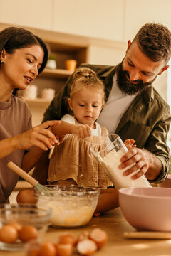 Family baking together, parents teaching child cooking skills