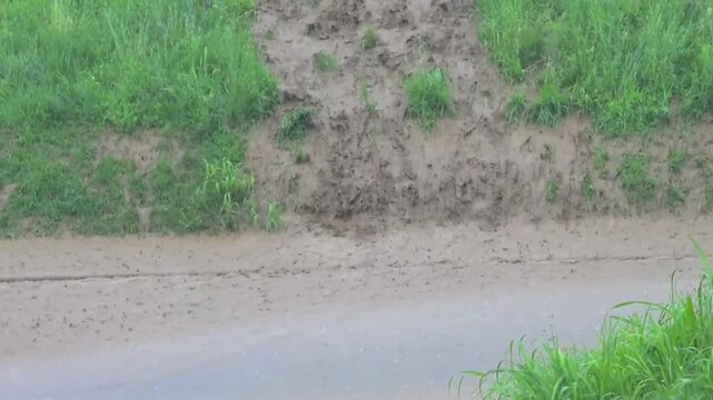 torrential rainfall, heavy rain fall, flood, mud streams running down the street, downpour 
