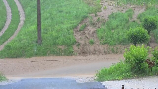 torrential rainfall, heavy rain fall, flood, mud streams running down the street, downpour 