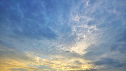 Obraz premium Beautiful Evening Sky Background, Golden Sunlight Piercing Through Stormy Blue Clouds landscape.