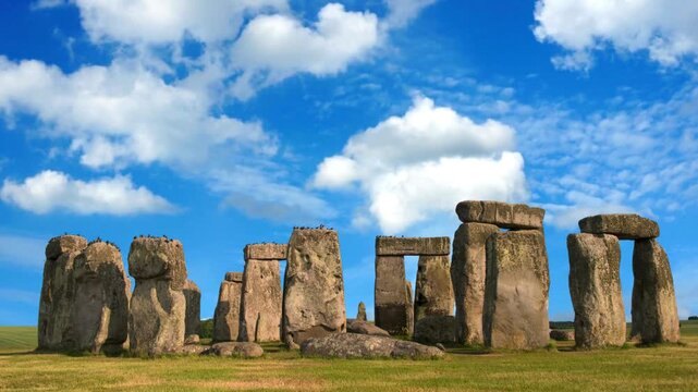 Exploring and stunning view of  ancient stones circle at Stonehenge under a bright blue Sky. UNHCR world heritage site and old civilization history . Nature wonders and unique spots. 