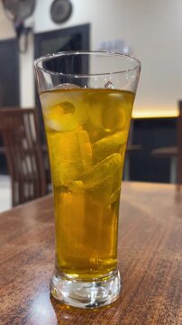 Glass of iced tea on wooden table in restaurant