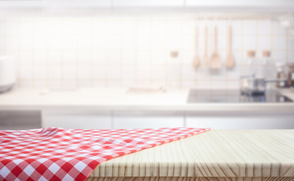 Selective focus.Fabric cloth or placemat on wood table top on blur white kitchen room