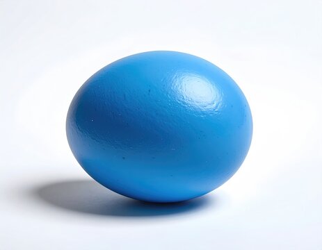 A bright blue, smooth, round object casts a soft shadow on a white background