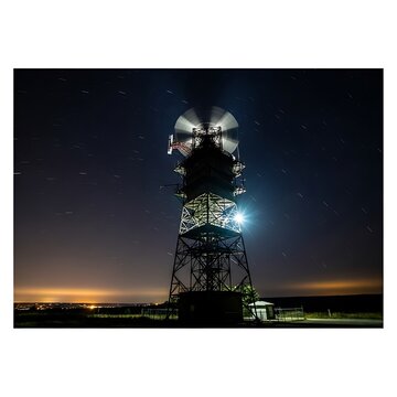 Nighttime Satellite Dish Tower with Bright Lights and Clear Sky.