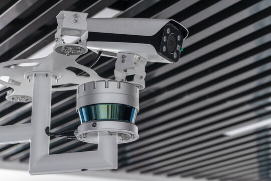 Ceiling-mounted surveillance setup featuring a security camera, CCTV unit and lidar sensor in a modern interior. Ideal concept image for monitoring, safety, technology and security