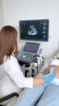 The pregnant woman is lying down in a hospital, doctor using ultrasound equipment screening of pregnant woman. Patient at ultrasonography examination. Family planning and IVF centers concept. Footage