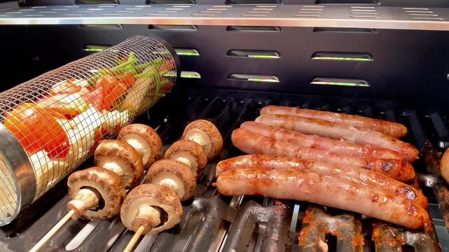  Close Up of Sausages and Mushroom Skewers Grilling on Gas Barbecue