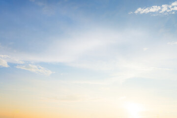 Fototapeta premium Dramatic golden hour sky with soft clouds at sunset,A beautiful and serene view of a golden hour sky, featuring soft, wispy clouds illuminated by the warm, gentle light of the setting sun, creating.