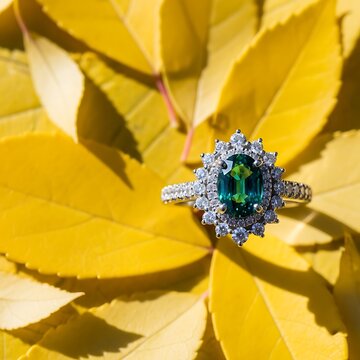 Elegant Emerald and Diamond Ring on Yellow Leaves.