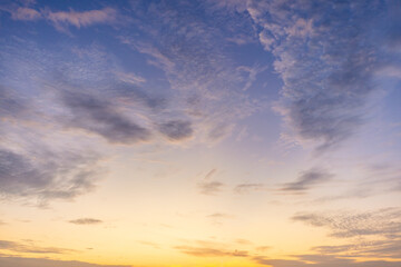 Fototapeta premium Dramatic golden hour sky with soft clouds at sunset,A beautiful and serene view of a golden hour sky, featuring soft, wispy clouds illuminated by the warm, gentle light of the setting sun, creating.
