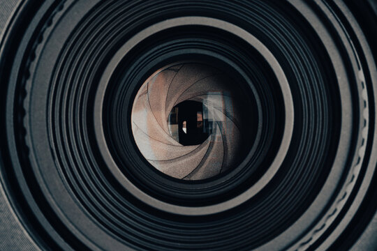 Close-up of Camera Lens Aperture with Green Reflection,Macro,A detailed macro shot capturing the intricate iris diaphragm blades of a camera lens with a prominent green light reflection on the glass s