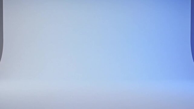 Clean and empty photography studio backdrop with soft blue and white gradient lighting for product placement