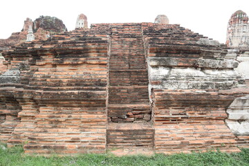 Fototapeta premium Ancient Temple Steps: Weathered brick steps ascend a crumbling temple structure, showcasing intricate historical architecture against a hazy sky. A testament to time and resilience.