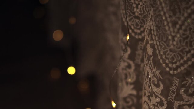 Close-up of vintage patterned lace with glowing garland lights