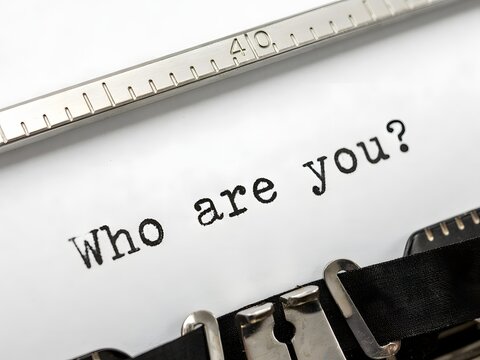 Who are you question typed on paper with typewriter and ruler, concept for identity and self-discovery