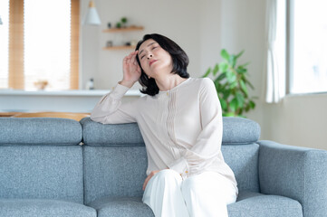 頭痛や体調不良に悩むシニア女性 © M