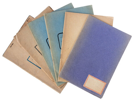 Stack of vintage paper school notebooks with worn blue and brown covers isolated on white