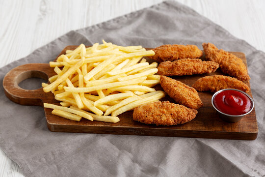 Homemade Crispy Chicken Tenders with Fries and Ketchup, side view.