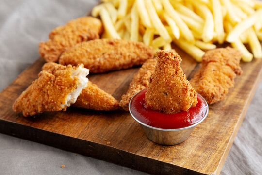 Homemade Crispy Chicken Tenders with Fries and Ketchup, side view. Close-up.