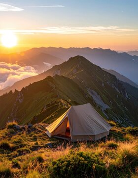 A solitary tent stands on a grassy mountain ridge at sunrise.
