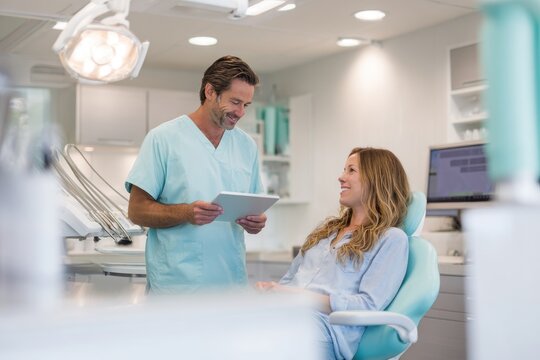 Gentle dental consultation between a male dentist and female patient in a bright clinic
