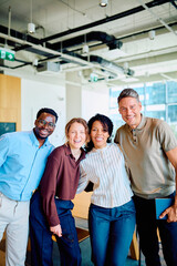 Naklejka premium Diverse business colleagues smiling and embracing in a contemporary office setting, representing teamwork, unity, and success
