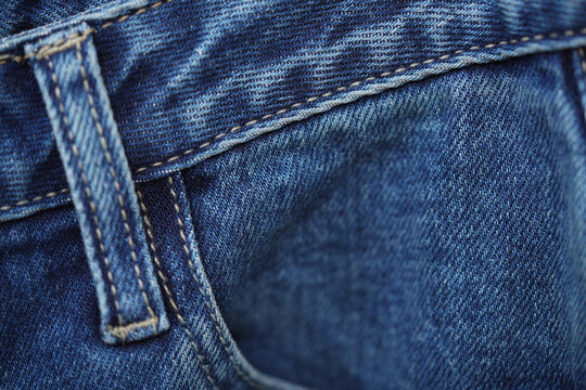 Front pocket and small pocket blue jeans pants with seam of fashion design. close up, macro. concept business, shopping, sale. Design detail, button and seams, copy space