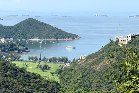 Scenic coastal landscape with golf course and sailboats in a bay