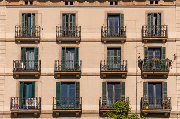 Obraz premium Building Facade With French Balconies and Wooden Shutters in Barcelona City in Spain