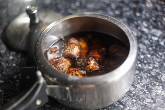 Boiled taro root cooking in a stainless steel pot