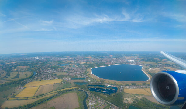 Water Storage Landmark: High-Altitude Aerial View of Queen Mother Reservoir, Berkshire Countryside, and Jet Engine from an Airplane Window, Near Heathrow Airport, England